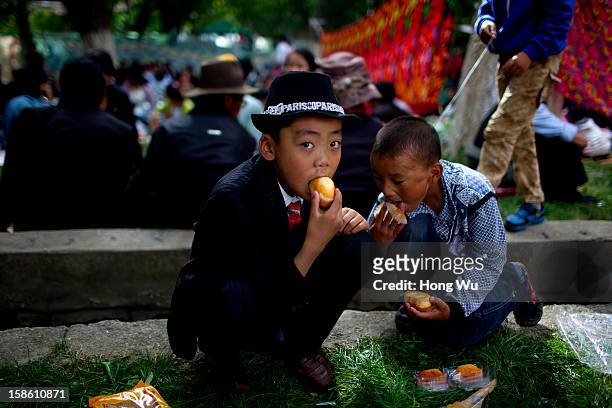 Tibetan children eat foods during the Sho Dun Festival in Norbulingka on August 18, 2012 in Lhasa, China. Lhasa is the administrative capital of the...