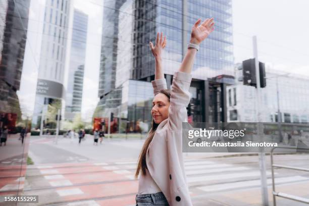 young woman with raised hands at the crossing in the city center - daily life in warsaw bildbanksfoton och bilder