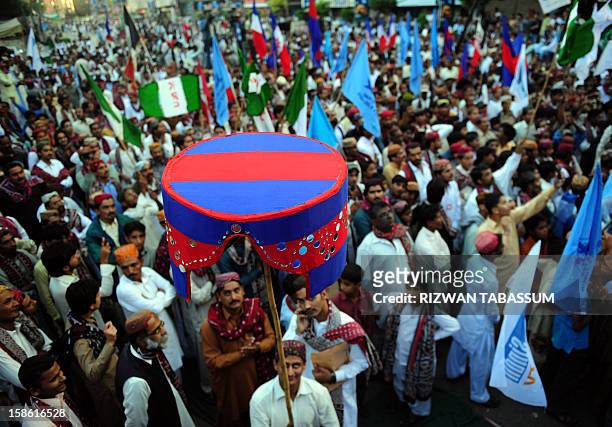 Pakistani revellers wearing traditional Sindhi cap and ajrak attire celebrate during a Sindh Cultural Day festival in Karachi on December 21, 2012....
