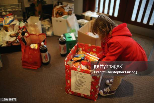 Three-year-old Lexie Hay looks through donations of food at Liverpool Foodbank as she waits with her mum to collect essential provisions for...