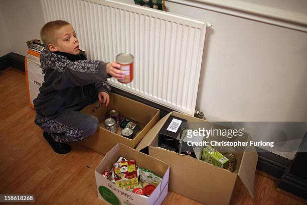 Eight-year-old Ryan Morris sifts through boxes of donated food for Christmas at Liverpool Foodbank on December 21, 2012 in Liverpool, England. With...