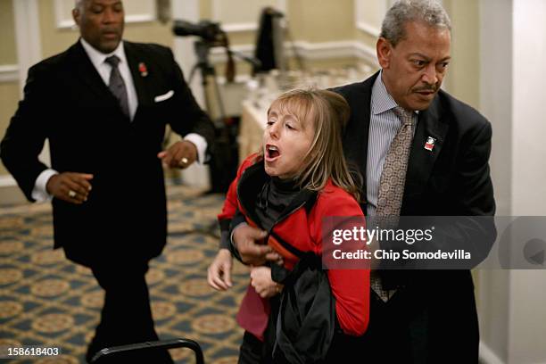 Activist Medea Benjamin of CodePink is carried away by security guards after interrupting a National Rifle Association news conference at the Willard...