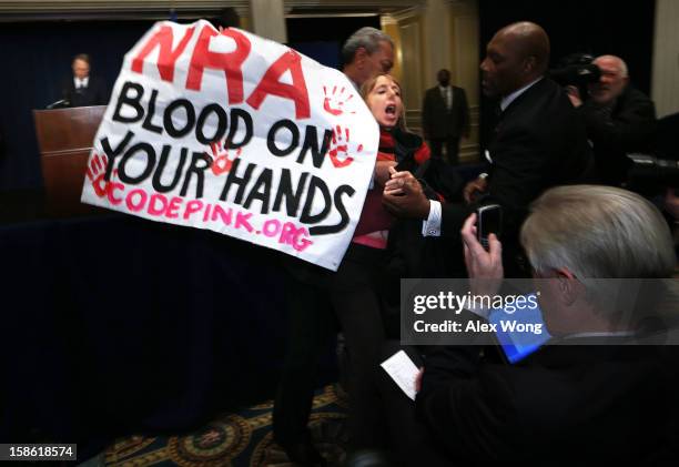Medea Benjamin of CodePink is removed by a secretary personnel as she protests during NRA CEO and Executive Vice President Wayne LaPierre's news...