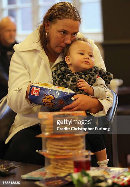 Elaine Oliver holds her daughter Safiyah Lesley, aged 14 months, after collecting essential Christmas food on December 21, 2012 in Liverpool,...