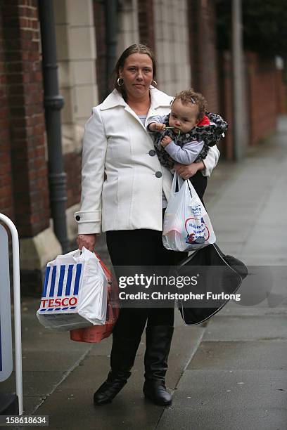 Elaine Oliver holds her daughter Safiyah Lesley, aged 14 months, after collecting essential Christmas food on December 21, 2012 in Liverpool,...