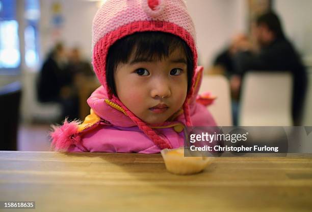 Ziyi Fang, aged 2, is given a cupcake as she waits with her mother to collect essential Christmas food at Liverpool Central Foodbank on December 21,...