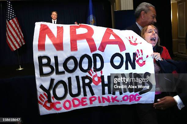 Medea Benjamin of CodePink is removed by a secretary personnel as she protests during NRA CEO and Executive Vice President Wayne LaPierre's news...
