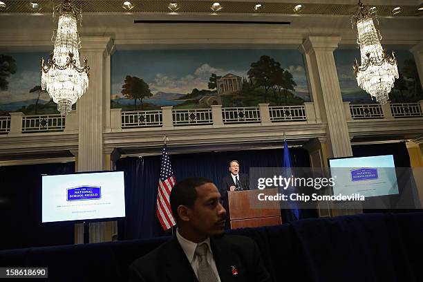 Security guard sits in front of National Rifle Association Executive Vice President Wayne LaPierre as he called on Congress to pass a law putting...