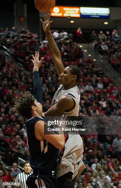 Skylar Spencer of the San Diego State Aztecs shoots the ball in the first half of the game against John Sinis of the University of San Diego Toreros...