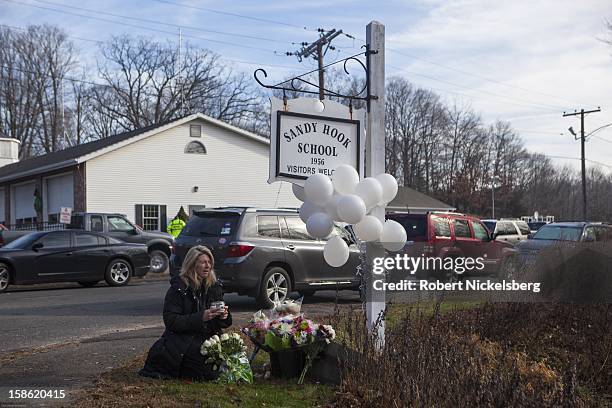 Local residents place flowers near the Sandy Hook Elementary School December 15, 2012 in Sandy Hook, Connecticut for the 28 children and faculty shot...