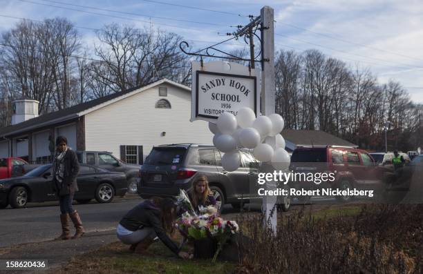 Local residents place flowers near the Sandy Hook Elementary School December 15, 2012 in Sandy Hook, Connecticut for the 28 children and faculty shot...