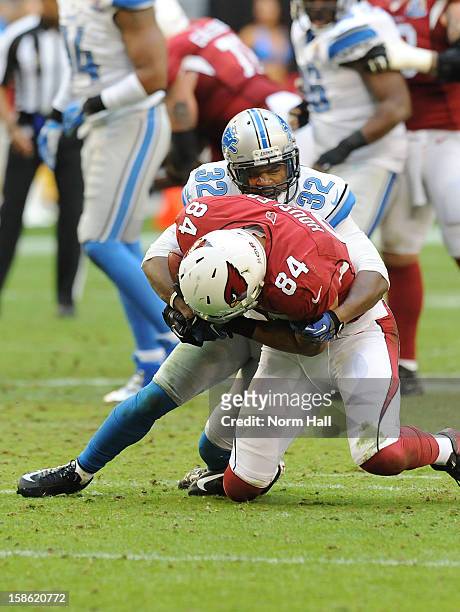 Don Carey of the Detroit Lions tackles Rob Housler of the Arizona Cardinals at University of Phoenix Stadium on December 16, 2012 in Glendale,...