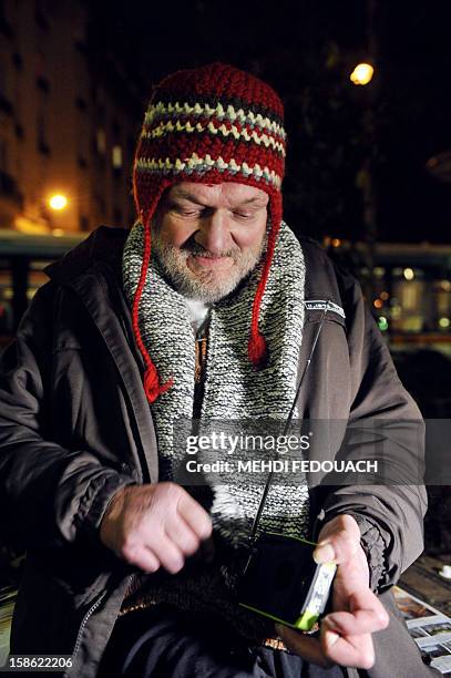Homeless man listens to a radio distribued by members of the Association "Les Enfants du Canal", in a street in Paris, on December 21, 2012....