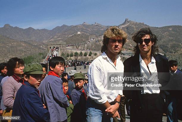 Young children sporting "Mao" jackets and caps gape at George Michael and Andrew Ridgeley, of the pop group Wham who are visiting the Great Wall as...