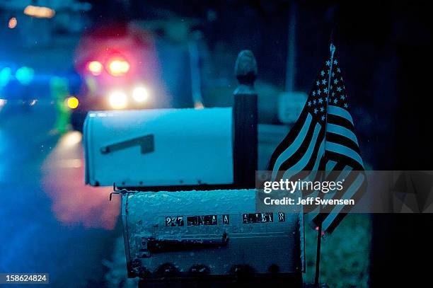 Flag waves from a mailbox as Blair County Sheriffs Deputies stand at the road block in Blair County on December 21, 2012 in Frankstown Township,...