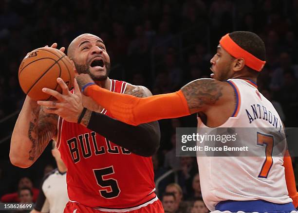 Carmelo Anthony of the New York Knicks fouls Carlos Boozer of the Chicago Bulls in the second quarter at Madison Square Garden on December 21, 2012...