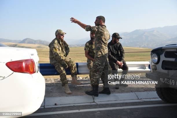 Armenian war veterans and army volunteers are seen blocked by law enforcement officers on a road just before the Lachin corridor after the group...