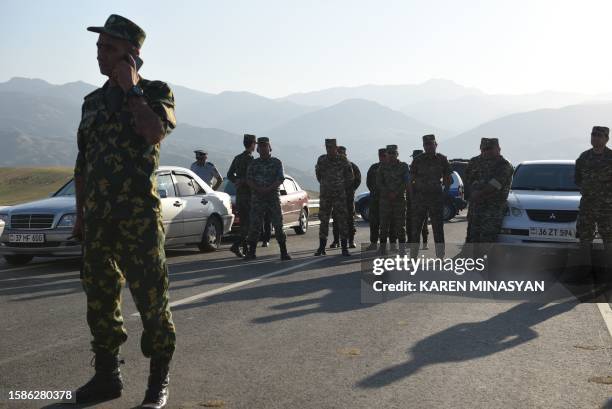 Armenian war veterans and army volunteers are seen blocked by law enforcement officers on a road just before the Lachin corridor after the group...