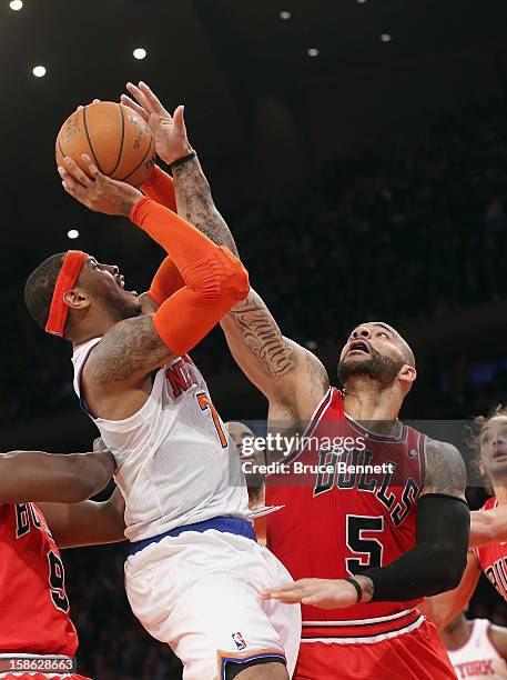 Carmelo Anthony of the New York Knicks is blocked by Carlos Boozer of the Chicago Bulls during the second quarter at Madison Square Garden on...