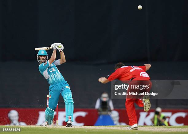 Ben Cutting of the Brisbane Heat hits the ball back over Darren Pattinson of the Melbourne Renegades during the Big Bash League match between the...