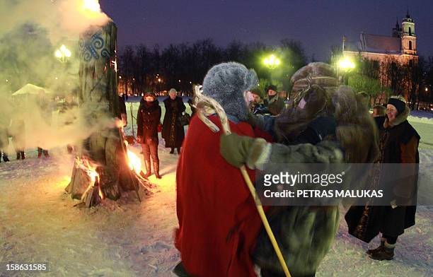 People participate in winter solstice celebrations to complete the Christmas 'Blukis' burning ceremony at Lukiskes Square in Vilnius on December 21,...