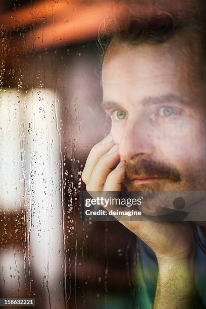 man looks through the window, rain - window rain stock pictures, royalty-free photos & images