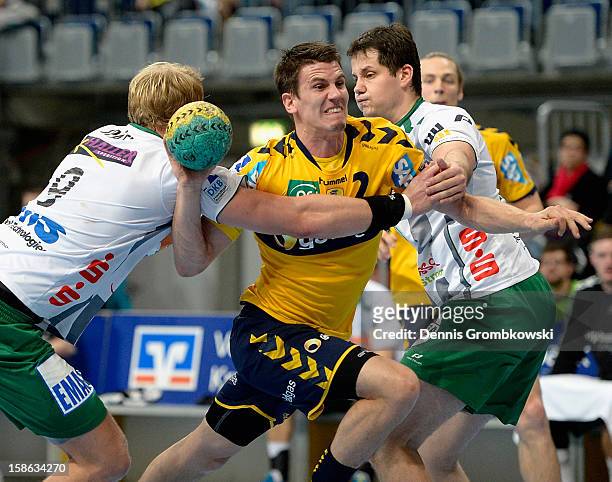 Andy Schmid of Rhein-Neckar Loewen is challenged by Manuel Spaeth and Bojan Beljanski of Goeppingen during the DKB Handball Bundesliga match between...