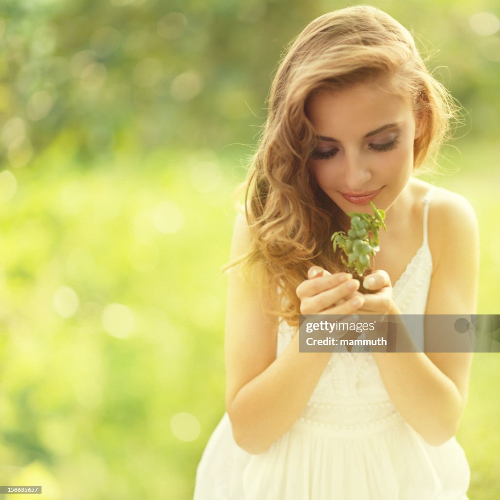 Proteger a natureza-menina segurando uma pequena planta