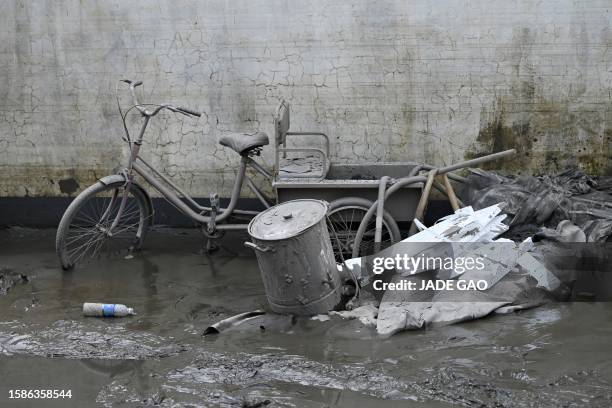 Tricycle covered with mud is seen by a villager's house in the aftermath of flooding from heavy rains in Zhuozhou city, in northern China's Hebei...