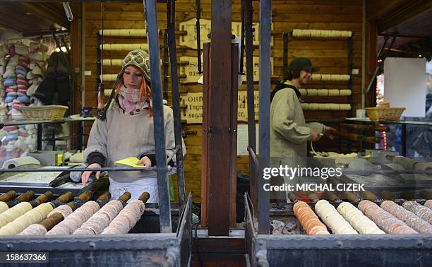 Street vendors grill Czech traditional pastry ''Trdelnik'' at a Christmas Market in Prague on December 22, 2012. AFP PHOTO MICHAL CIZEK
