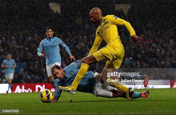 Pablo Zabaleta of Manchester City goes down under the challenge of Jimmy Kebe of Reading during the Barclays Premier League match between Manchester...