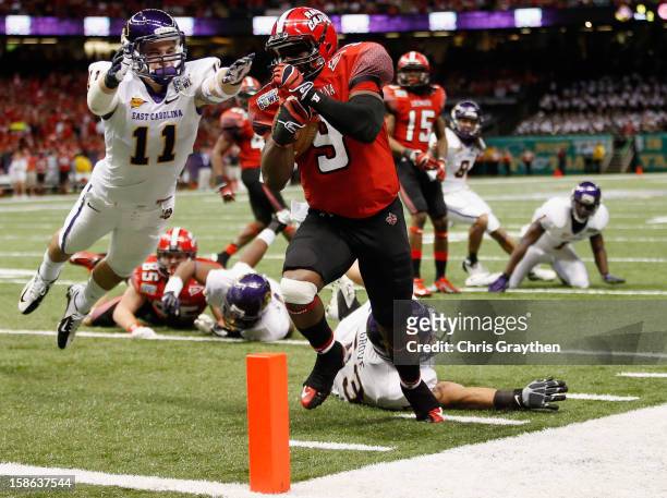 Harry Peoples of the Louisiana-Lafayette Ragin Cajuns scores a touchdown over Damon Magazu of the East Carolina Pirates during the R+L Carriers New...