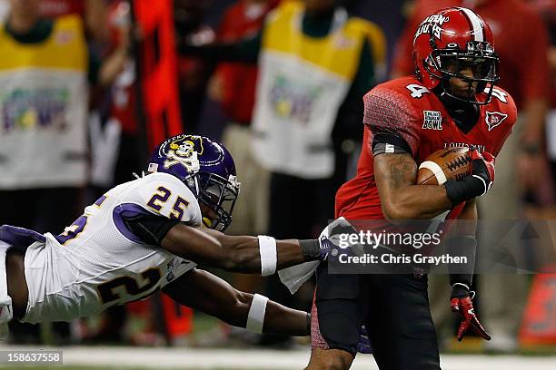 Javone Lawson of the Louisiana-Lafayette Ragin Cajuns is tackled by Leonard Paulk of the East Carolina Pirates during the R+L Carriers New Orleans...