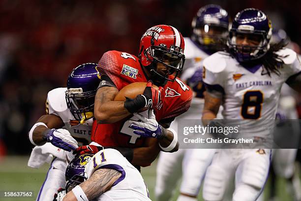 Javone Lawson of the Louisiana-Lafayette Ragin Cajuns is tackled by Leonard Paulk of the East Carolina Pirates during the R+L Carriers New Orleans...