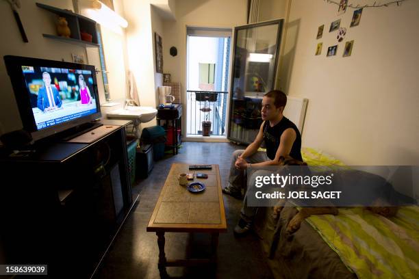 Ludovic and his dog Ris, looks at TV in his room at the homeless shelter "Les enfants du canal" , a homeless shelter where dogs are allowed, on...