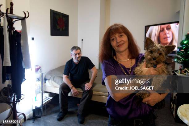 Jean-Paul , his partner Annie , and their dog Folk, pose for a picture in their room at the homeless shelter "Les enfants du canal" , a homeless...