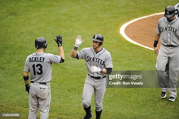 Casper Wells is greeted by Dustin Ackley of the Seattle Mariners hitting a three-run home run during the game against the Chicago White Sox on...