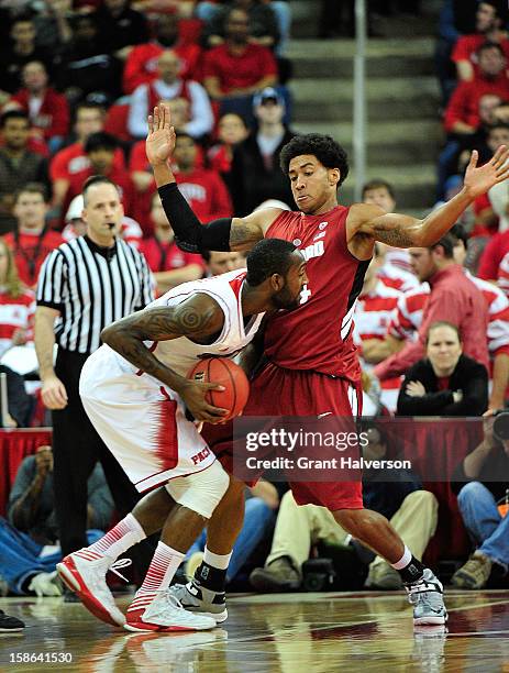 Josh Heustes of the Stanford Cardinal defends a drive by C.J. Leslie of the North Carolina State Wolfpack during play at PNC Arena on December 18,...