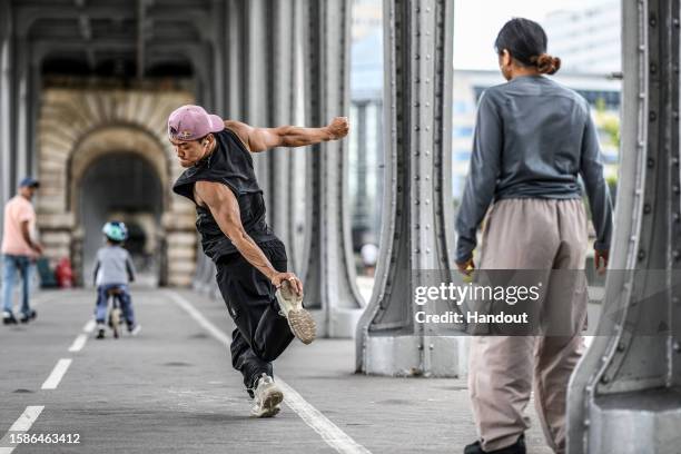 In this handout image provided by Red Bull, B-boy Phil Wizard of Canada performs at Pont de Bir-Hakeim while Logistix of the USA watches on during...