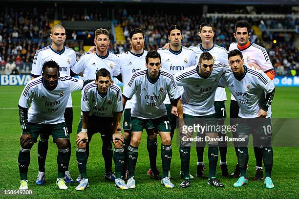 Real Madrid CF players pose wearing a jersey in support to Head coach Tito Vilanova of FC Barcelona prior to the La Liga match between Malaga CF and...