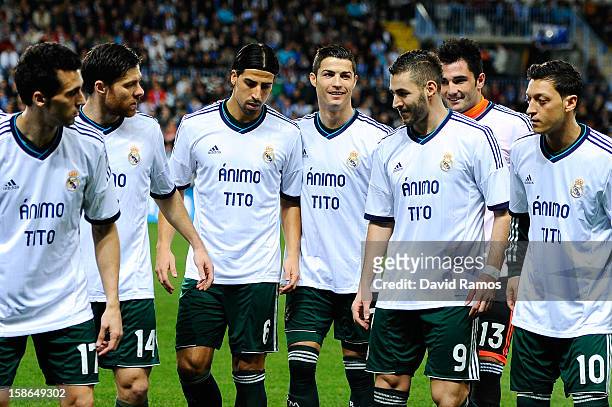 Real Madrid CF players wear a jersey in support to Head coach Tito Vilanova of FC Barcelona prior to the La Liga match between Malaga CF and Real...