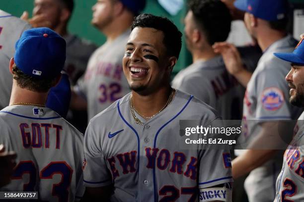 Mark Vientos of the New York Mets smiles as he walks through the dugout after hitting a sacrifice fly in the eighth inning against the Kansas City...