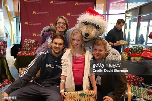 Lou Amundson and mascot Crunch of the Minnesota Timberwolves pause from distributing holiday gifts collected through the Minnesota Timberwolves...