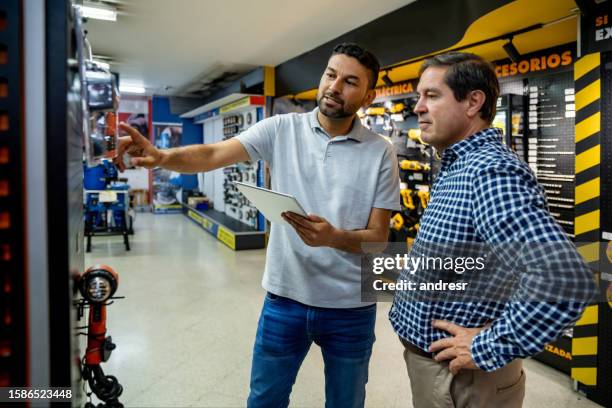 empleado minorista que ayuda a un cliente a comprar herramientas en una ferretería - oficio de ventas fotografías e imágenes de stock