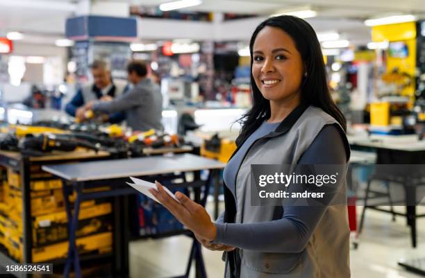 glückliche verkäuferin arbeitet in einem baumarkt - personal assistant device stock-fotos und bilder