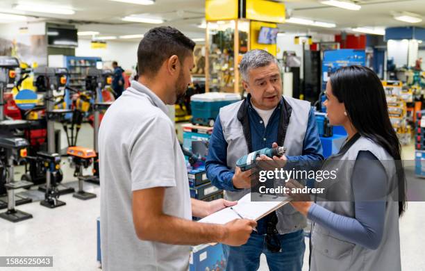 business manager training two workers at a hardware store - workshop tools stock pictures, royalty-free photos & images