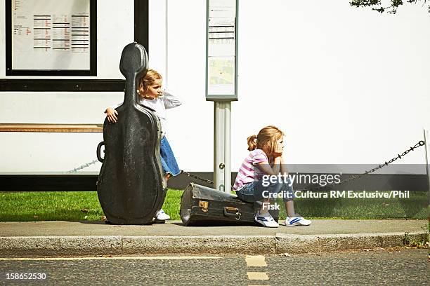 children at bus stop with instruments - tube foto e immagini stock