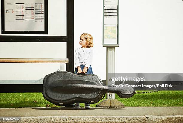 girl at bus stop with cello case - girl cello stock pictures, royalty-free photos & images