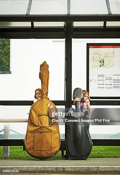 children at bus stop with instruments - double bass stock pictures, royalty-free photos & images