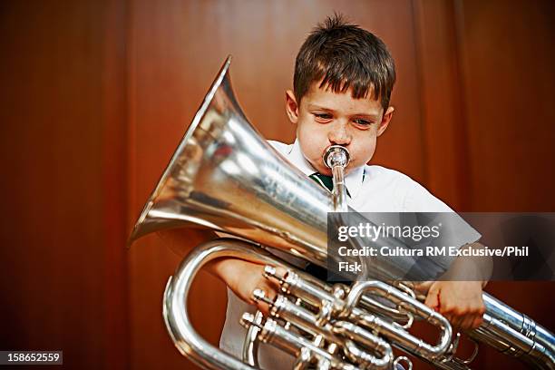 boy playing tuba - tube foto e immagini stock